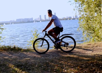 Cyclist jerking in public place meeting the beautiful sunset