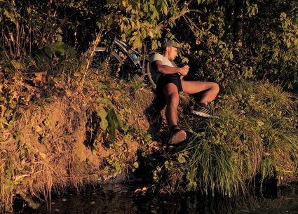 Cyclist jerking in public place meeting the beautiful sunset