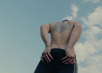 Teen muscle guy poses after riding a scooter