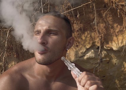 Muscle man smoking naked on the beach